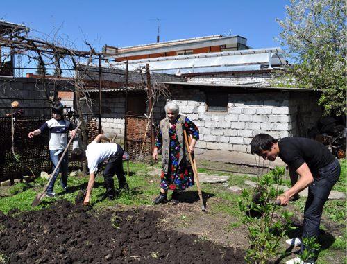 Подростки оказывают помощь пенсионерке в уборке территории. Северная Осетия, Владикавказ, июль 2010 г. Фото "Кавказского узла"