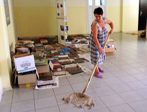 Тетя Катя, сотрудница техперсонала школы №30, отмывает здание после наводнения. Фото предоставлено учащимися школы №30