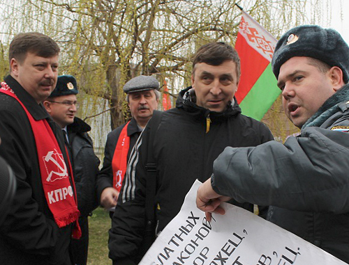 Сотрудник полиции сворачивает плакат. Краснодар, 23 марта 2013 г. Фото Андрея Кошика для "Кавказского узла"