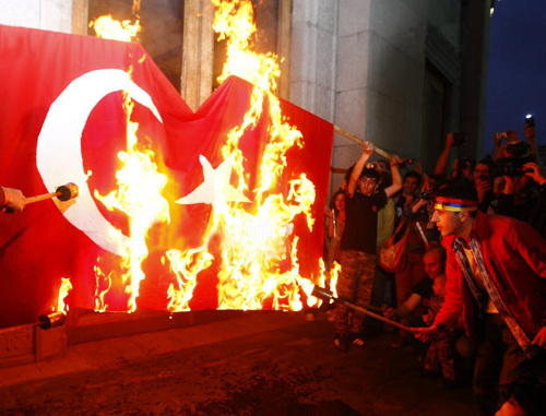 Участники факельного шествия, посвященного памяти жертв геноцида армян в Османской Турции, зажигают факелы от горящего турецкого флага. Армения, Ереван, 23 апреля 2012 г. Фото: © PanARMENIAN Photo / Vahan Stepanyan