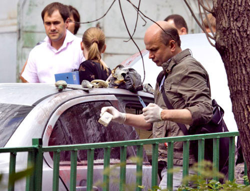 Оперативный сотрудник возле автомобиля Mitsubishi Lancer, который преступник облил и поджег. Москва, 10 июня 2011 г. Фото: Yuri Timofeyev (RFE/RL)