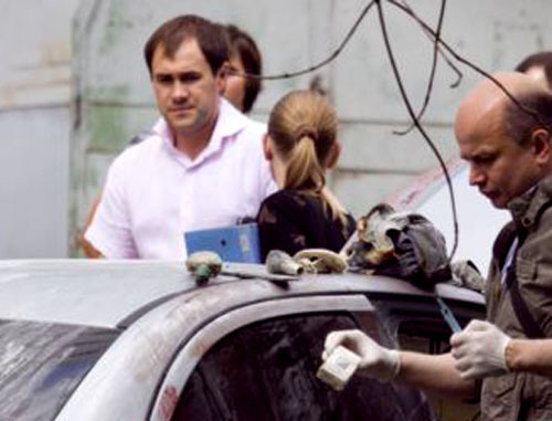 Работают криминалисты возле машины Mitsubishi Lancer, которая была сожжена. Москва, 10 июня 2011 г. Фото: Yuri Timofeyev (RFE/RL)