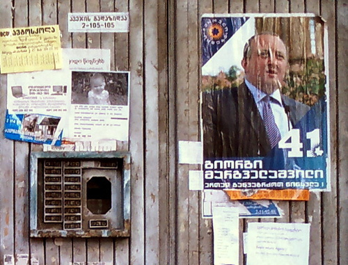 Предвыборный плакат Георгия Маргвелашвили на двери в подъезд многоквартирного дома. Тбилиси, 26 октября 2013 г. Фото Григория Шведова для "Кавказского узла" 