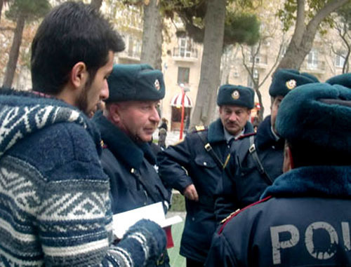 Полиция общается с участником акции молодежи "Читай книгу". Баку, 6 декабря 2011 г. Фото http://anspress.com/