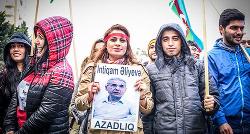 Участники акции протеста в Баку держат в руках плакат с изображением Интигама Алиева. Фото Азиза Каримова для "Кавкуазского узла"