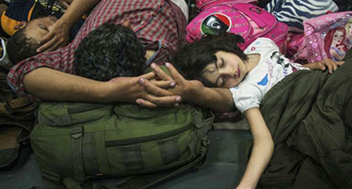 Изнуренная сирийская девочка спит рядом с отцом после спасения итальянским военным судном в Средиземном море. Фото: @UNHCR/A.D’Amato, http://www.unhcr.ru/