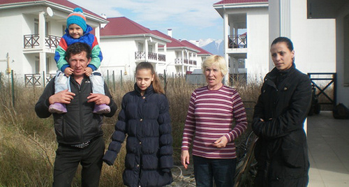 Семья Савельевых перед пустующими домами в поселке для переселенцев. Фото Алексея Савельева