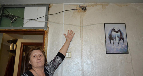 Жительница дома 33 по ул. Донская показывает, как заливает при каждом дожде. Фото Светланы Кравченко для "Кавказского узла"
