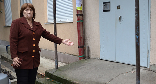 Представитель домкома дома № 92 по ул. Донской показывает разрушающиеся ступени в подъезд. Фото Светланы Кравченко для "Кавказского узла"

