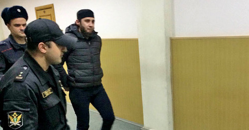 Заура Дадаева ведут по коридору суда. Фото Юлии Буславской для "Кавказского узла"