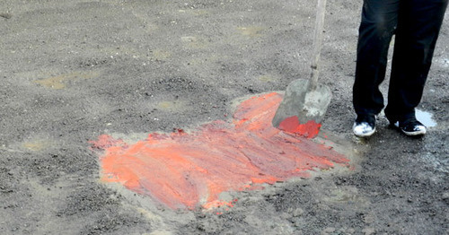 Участники акции закрасили яму на дороге в красный цвет. Волгоград, 21 февраля 2016 г. Фото Татьяны Филимоновой для "Кавказского узла"