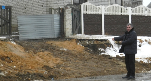 Житель Гумрака показывает, каким стал въезд в его двор в результате реконструкции трассы. Фото Татьяны Филимоновой для "Кавказского узла"