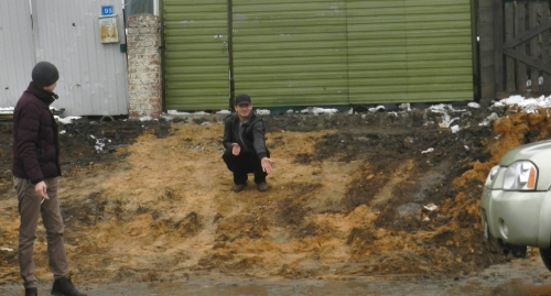 Житель Гумрака показывает, как теперь выглядит въезд в его двор. Фото Татьяны Филимоновой для "Кавказского узла"