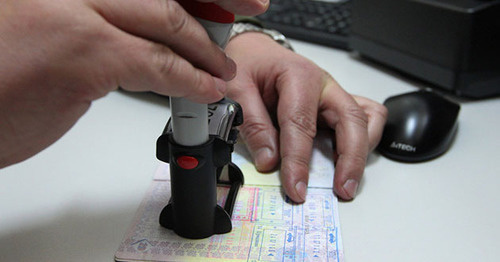 Работник таможенной службы ставит печать в пасморт. Фото: Sputnik/Андрей Александров