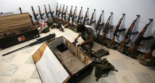 Боевик 'Аль-Султан Мурад бригады' на складе оружия  на севере Сирии. Фото Khalil Ashawi/ REUTERS