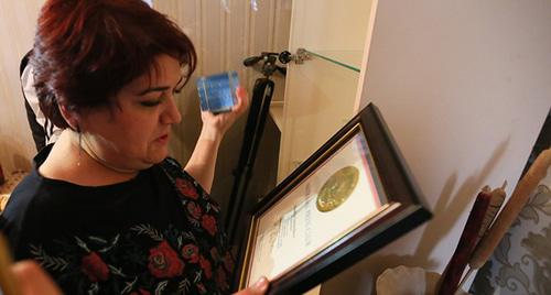 Хадиджа изучает документы о получении Всемирную премию ЮНЕСКО за свободу печати имени Гильермо Кано. Фото Азиза Каримова для "Кавказского узла"