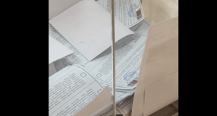 Пачка с бюллетенями в избирательной урне на участке в Краснодаре. Стоп-кадр видео, опубликованного на сайте "Карта нарушений" 16.03.24, https://www.kartanarusheniy.org/messages