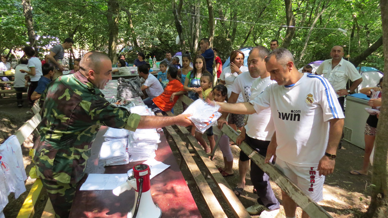 Комендант лагеря Вардан Вирабян раздаёт маечки участникам соревнования.