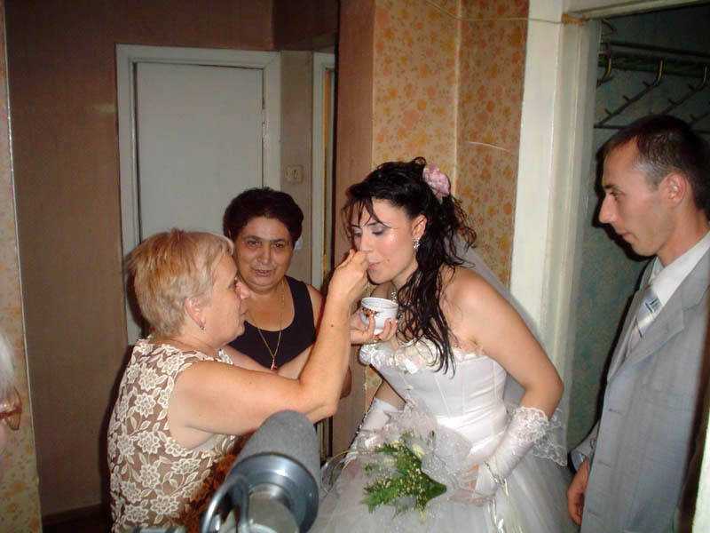 Невеста переступает порог дома жениха, разбивает ногой тарелку и свекровь даёт ей ложку мёда.