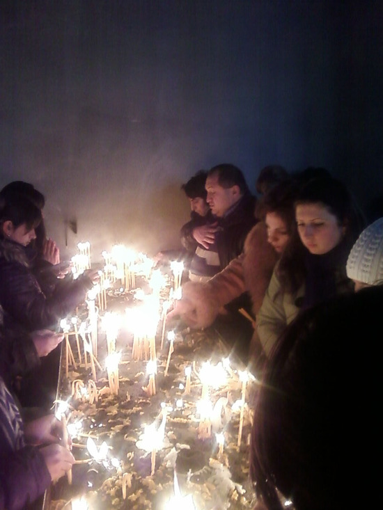 Верующие ставят свечи в честь Рождества Христова. 