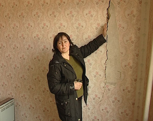 Сусанна Богосян показывает щели, образовавшиеся в стене дома. Фото "Кавказского Узла"