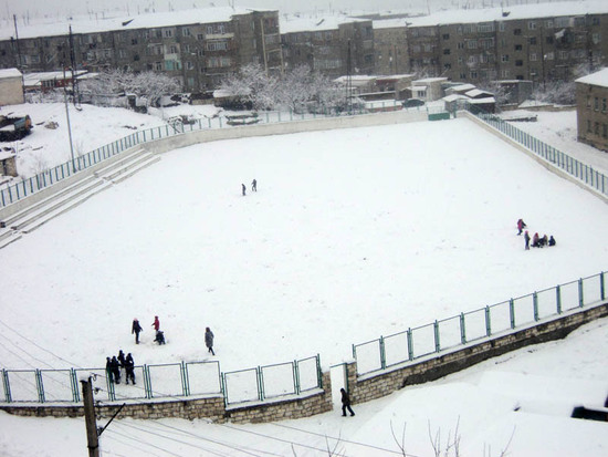 Дети облюбовали стадион для игры в снежки.