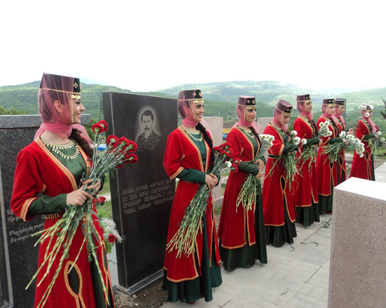 Девушки в национальной одежде приготовили цветы, чтобы дать тем, кто придёт почтить память погибшим в Карабахской войне (нижняя часть "Братской могилы, где похоронены погибших в этой войне).
