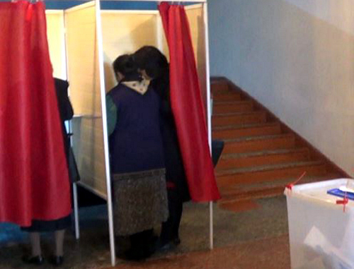 Голосование на выборах президента Азербайджана. Два человека зашли в одну кабинку для голосования. Баку, 9 октября 2013 г. Кадр из видео, http://www.azadliq.org/content/article/25131188.html