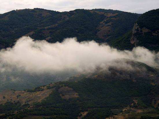 Низкие облака, практически ложатся на склоны гор.