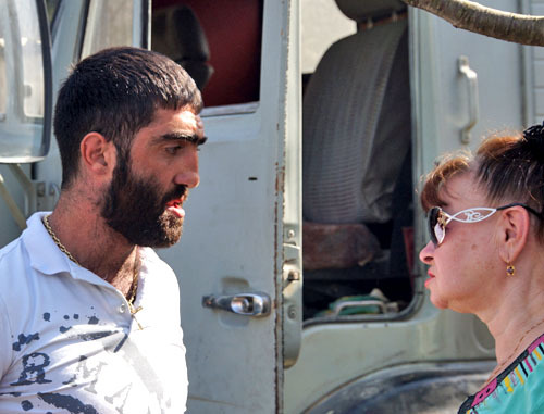 Спор между жительницей Кудепсты и работником базы, КАМАЗ которого блокировали жители Кудепсты. Сочи, 17 октября 2013 г. Фото Павла Лиманова