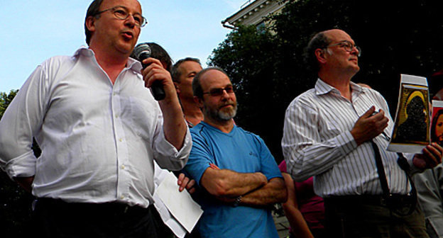 Андрей Ерофеев (у микрофона) и Юрий Самодуров (с копиями экспонатов выставки "Запретное искусство" в руках) на Чистых прудах в Москве, 9 июля 2010 года. Фото "Кавказского узла"