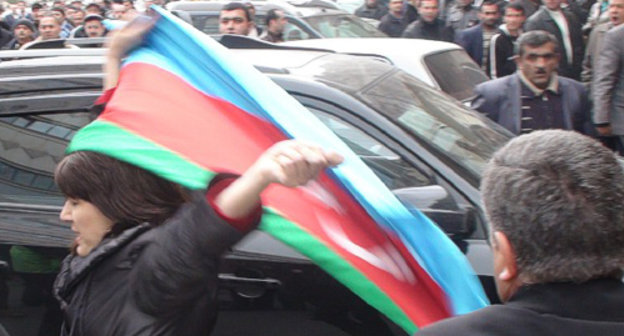 Неизвестная активистка оппозиции с государственным флагом
Азербайджана возле сада "Хагани" в Баку во время акции протеста 2 апреля 2011 г. Фото "Кавказского узла"