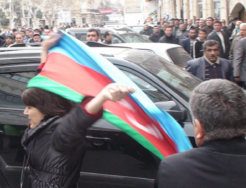 Неизвестная активистка оппозиции с государственным флагом
Азербайджана возле сада "Хагани" в Баку во время акции протеста 2 апреля 2011 г. Фото "Кавказского узла"
