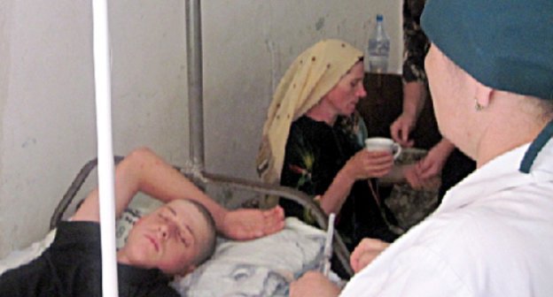 Подросток, избитый милиционерами, в районной больнице. На заднем плане его мать, Айшат Гусейнова. Дагестан, Шамильский район, июль 2010 г. Фото: ПЦ "Мемориал", www.memo.ru