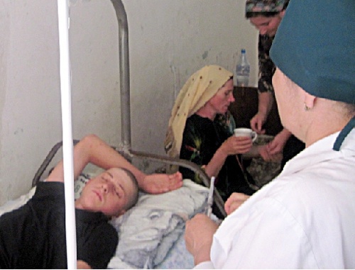 Подросток, избитый милиционерами, в районной больнице. На заднем плане его мать, Айшат Гусейнова. Дагестан, Шамильский район, июль 2010 г. Фото: ПЦ "Мемориал", www.memo.ru
