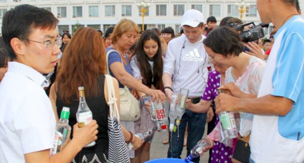 Жители и гости Элисты публично выливают спиртные напитки в ведро. Калмыкия, 11 июня 2011 года. Фото пресс-службы Центрального хурула "Золотая обитель Будды Шакьямуни".