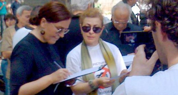 Журналист, депутат Тбилисского органа самоуправления Инга Григолия подписывает обращение с просьбой об освобождении на поруки арестованных фотожурналистов на акции солидарности у посольства ФРГ.  Тбилиси, 15 июля 2011 г. Фото "Кавказского узла"  