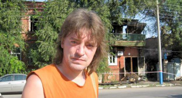 Жилец дома 28 по ул. М. Горького Александр Мурзов на фоне сгоревшего здания. Астрахань, 28 июля 2011 г. Фото "Кавказского узла"