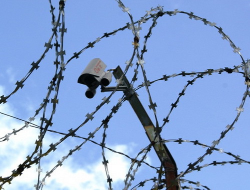 Колючая проволока и камера слежения над тюремной стеной. Фото пресс-службы УФСИН России по Архангельской области