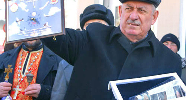 21 февраля 2012 г. Северная Осетия, г. Владикавказ. Мемориальная доска в честь авиатора Артема Кацияна установлена на здании дома, в котором он родился и вырос. На снимке: генерал авиации в отставке Руслан Бедоев с памятными часами в честь первого полета Артема Кацияна над Владикавказом. Фото Владимира Иванова для "Кавказского узла"