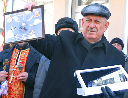 21 февраля 2012 г. Северная Осетия, г. Владикавказ. Мемориальная доска в честь авиатора Артема Кацияна установлена на здании дома, в котором он родился и вырос. На снимке: генерал авиации в отставке Руслан Бедоев с памятными часами в честь первого полета Артема Кацияна над Владикавказом. Фото Владимира Иванова для "Кавказского узла"