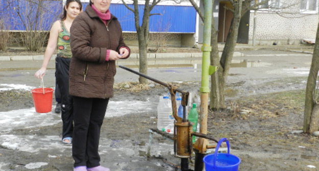 Адыгея, Майкопский район, поселок Удобное, март 2012 г. Жители набирают воду из колонки. Фото Леонида Мертца.