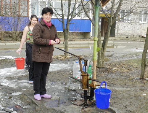 Адыгея, Майкопский район, поселок Удобное, март 2012 г. Жители набирают воду из колонки. Фото Леонида Мертца.