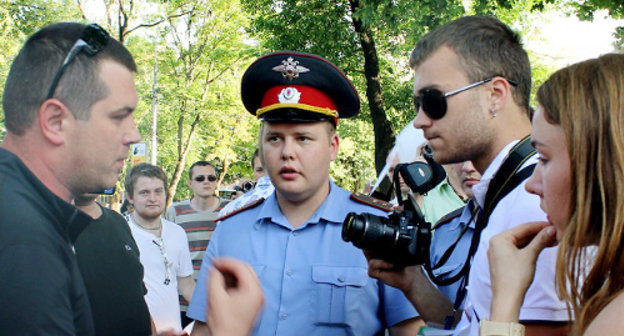 Ведущий специалист отдела энергосбережения департамента городского хозяйства администрации Краснодара Виталий Беляк (слева) требует от участников акции "белых ленточек" покинуть территорию перед краевой администрацией. Краснодар, 20 мая 2012 г. Фото Никиты Серебрянникова для "Кавказского узла"
 