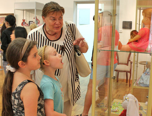 Благотворительная выставка в помощь детям, больным онкологией и выставка "Родом из детства" открылась в  музее изобразительных искусств. На снимке: бабушка показывает своим внучкам какая кукла была у нее в детстве. Ростов-на-Дону, 1 июня 2012. Фото Олеси Диановой для "Кавказского узла"