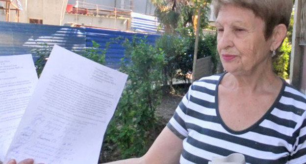 Член домового комитета Лидия Лазарева демонстрирует обращение жителей дома № 66 по улице Гагарина к главе города Анатолию Пахомову с требованием обеспечить жителям Сочи безопасность и порядок на территории их собственности. Сочи, 3 июня 2012 г. Фото Светланы Кравченко для "Кавказского узла"