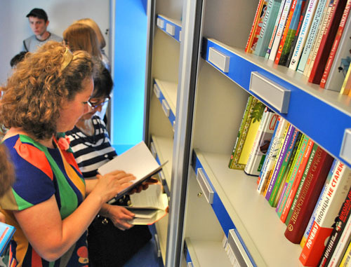 Начал курсировать "Библиобус" в Северной Осетии. На снимке: знакомство читателей с новинками
мобильного комплекса информационно-библиотечного обслуживания. Северная Осетия, Ардон. 7 июня 2012 г. Фото Дмитрия Тамерланова для "Кавказского узла"