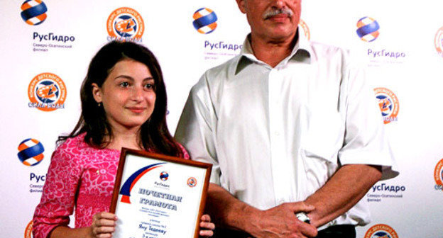 Председатель жюри Казбек Зангиев и призер конкурса Яна Тедеева в кинотеатре "Комсомолец" во время награждения победителей детского экологического конкурса "Сила воды". Северная Осетия, Владикавказ, 7 июня 2012 г. Фото Дмитрия Тамерланова для "Кавказского узла"