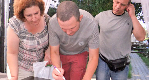 Бывшие сотрудники "Маринс парк отеля" провели акцию протеста. На снимке: сотрудники службы безопасности «Маринс парк отеля» ставят свои подписи под заявлением прокурору. Сочи, 16 июля 2012 г. Фото Светланы Кравченко для "Кавказского узла"