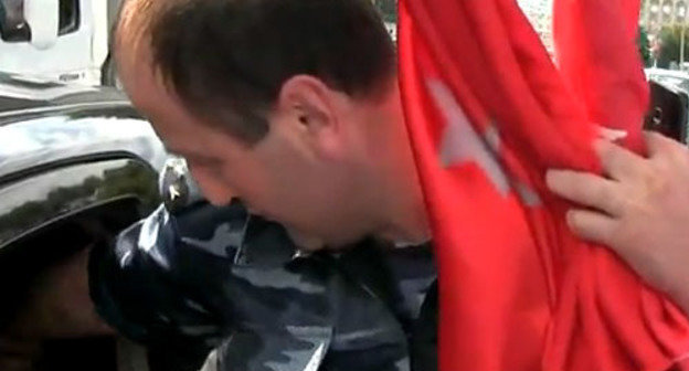 Изъятие флага абазин представителем МВД КЧР. Фото http://www.youtube.com